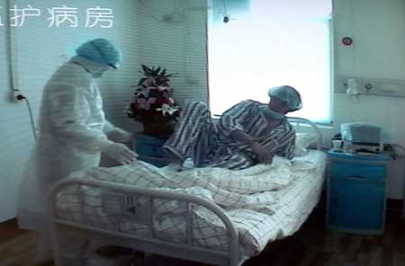 The photo taken on May 13, 2009 from video shows the confirmed A/H1N1 patient surnamed Lv (R) at an ICU of the Jinan Infectious Disease Hospital in Jinan, east China's Shandong Province. China's Ministry of Health confirmed Wednesday the 19-year-old student surnamed Lv who returned from Canada last week has tested positive for the A/H1N1 influenza. [Xinhua]