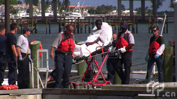 Coast Guard officials bring a survivor of a capsized boat to the U.S. Coast Guard station in Riviera Beach, Florida, Wednesday, May 13, 2009.[CFP]