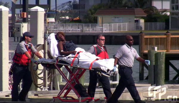 Coast Guard officials bring a survivor of a capsized boat to the U.S. Coast Guard station in Riviera Beach, Florida, Wednesday, May 13, 2009.[CFP]