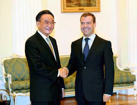 Russian President Dmitry Medvedev (R) shakes hands with Wu Bangguo, chairman of the Standing Committee of the National People's Congress (NPC) of China, in Moscow, capital of Russia, May 13, 2009.(Xinhua/Li Tao)