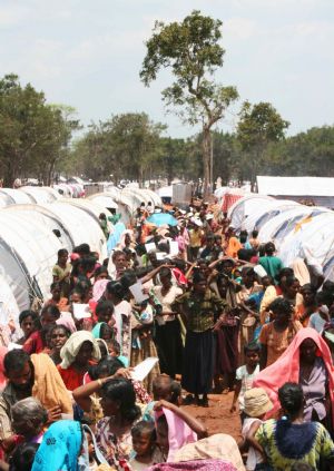 Tamil civilians stand in line to receive food and supplies in a refugee camp located on the outskirts of the town of Vavuniya in northern Sri Lanka May 8, 2009.