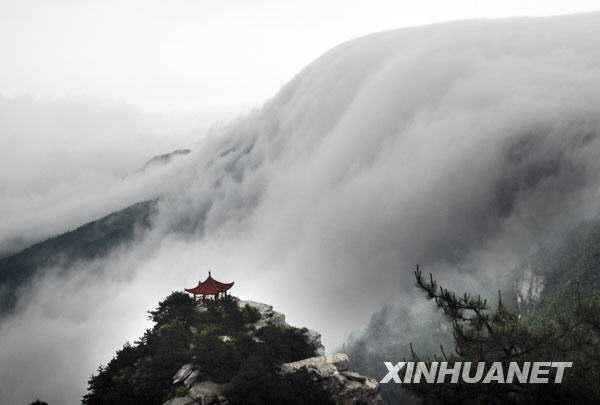 Photo taken on May 13, 2009 shows the torrent of the waterfall on Mount Lushan dashes down against a backdrop of dense drifting cloud, presenting a spectacular scene of a vast expanse of white cloud and mist over the mountain peaks mingling with the ample flow of the waterfall, in Lushan, east China&apos;s Jiangxi Province, May 13, 2009. [Photo:Xinhua/Yang Fan]