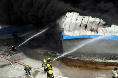 Firemen put out fire at the accident spot of a warehouse in Liubei District of Liuzhou, southwest China's Guangxi Zhuang Autonomous Region, May 14, 2009. A fire broke out around 10:00 am in a warehouse storing over 2,000 tons of sugar and over 3,000 refrigerators and air-conditioners. The fire is still not under control after burning for more than three hours by press time, said local sources on Thursday. 