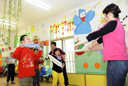 Students practice rhythmic gymnastic in a special education nursery school in Shenyang, May 13, 2009. The nursery school started in 1994, and has taught some 1000 handicapped students during the passed 15 years. (Xinhua/Ren Yong)