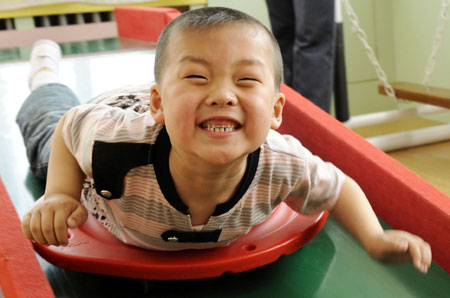 A student plays in a special education nursery school in Shenyang, May 13, 2009. The nursery school started in 1994, and has taught some 1000 handicapped students during the passed 15 years. (Xinhua/Ren Yong)