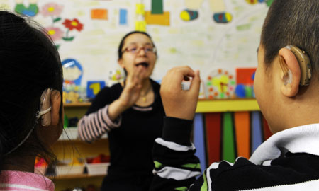 Zhe Ping teaches her deaf students to pronounce in a special education nursery school in Shenyang, May 13, 2009. The nursery school started in 1994, and has taught some 1000 handicapped students during the passed 15 years. (Xinhua/Ren Yong) 