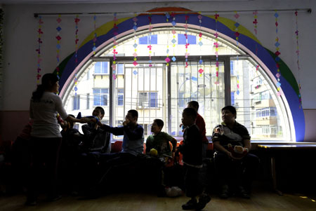 Students play with their teacher in a special education nursery school in Shenyang, May 13, 2009. The nursery school started in 1994, and has taught some 1000 handicapped students during the passed 15 years. (Xinhua/Ren Yong) 