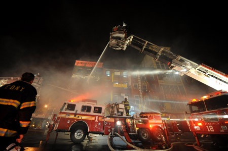 Firefighters try to put out a fire broke out at a supermarket in the Chinatown of Manhattan, New York, the United States, May 15, 2009. A fire broke out at the supermarket and spread to the market's building. No casualties were reported yet.(Xinhua/Shen Hong)