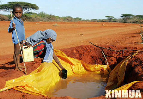 A mother and her son try to get water from a ditch on a roadside in Kenya on January 11, 2006. The east part of Africa was hit by severe drought in January-April 2006, resulting in shortage total crop failure, death of livestock and shortage of drinking water. 