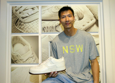 Chinese basketball player Yi Jianlian presents a shoe he designed when he attend a fans meeting held in Guangzhou, capital of south China's Guangdong Province, May 15, 2009. [Xinhua]