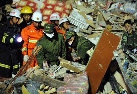 Rescuers find a body of a victim on the spot of a collaped building at the Jiuzhou Economic Development Zone in Lanzhou, capital of northwest China's Gansu Province, May 17, 2009. Part of the residence building collapsed due to a landslide on late Saturday in Lanzhou. The bodies of two victims have been found in the scene and one injured was rescued.(Xinhua/Han Chuanhao)