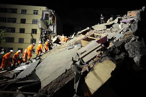 Rescuers search for survivors amid the ruins of a collapsed residential building at the Jiuzhou Economic Development Zone in Lanzhou, Gansu province May 16, 2009. Part of the building collapsed due to a landslide late Saturday, killing five people and leaving two others missing. [Photo: Xinhua] 