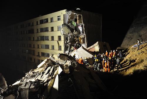 Rescuers search for survivors amid the ruins of a collapsed residential building at the Jiuzhou Economic Development Zone in Lanzhou, Gansu province May 16, 2009. Part of the building collapsed due to a landslide late Saturday, killing five people and leaving two others missing. [Photo: Xinhua] 