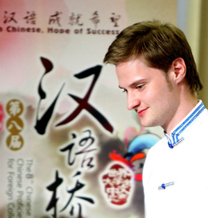 Contestant Grisha stands before a poster during the Moscow round of the the 'Chinese Bridge' competition, a Chinese-language proficiency contest for foreign college students in Moscow, capital of Russia, May 17, 2009. 