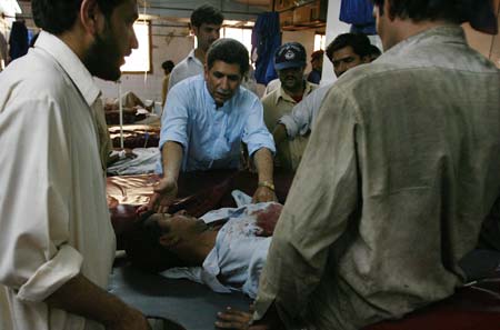 Hospital staff carry a victim who was injured in a bomb blast, at a hospital in Peshawar May 16, 2009. 