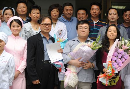 The A/H1N1 patient surnamed Bao (2nd R, Front) poses for a photo with his girlfriend (1st R, Front), his father (3rd R, Front) and medical staff in Chengdu, capital of southwest China's Sichuan Province, on May 17, 2009. The patient, who was China's first patient in the case of A/H1N1 flu, was discharged from hospital Sunday after recovery, local authorities said. (Xinhua/Chen Xie)