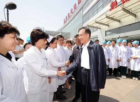 Chinese Premier Wen Jiabao (R) and Vice Premier Li Keqiang (2nd R) shake hands with medical staff of Beijing Ditan Hospital in Beijing, capital of China, May 17, 2009. Wen Jiabao and Li Keqiang on Sunday visited Beijing's first diagnosed A/H1N1 flu patient and medical staff at Beijing Ditan Hospital, and inspected the Chinese Center for Disease Control and Prevention. (Xinhua/Rao Aimin)