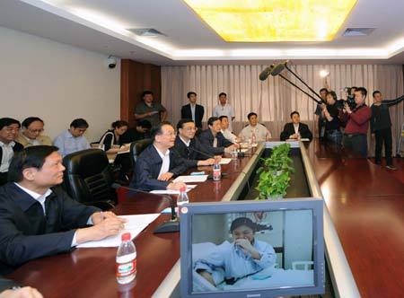 Chinese Premier Wen Jiabao (2nd L Front) and Vice Premier Li Keqiang (3rd L Front) talk via video with Beijing's first diagnosed A/H1N1 flu patient at Beijing Ditan Hospital in Beijing, capital of China, May 17, 2009. Wen Jiabao and Li Keqiang on Sunday visited Beijing's first diagnosed A/H1N1 flu patient and medical staff at Beijing Ditan Hospital, and inspected the Chinese Center for Disease Control and Prevention. (Xinhua/Rao Aimin)