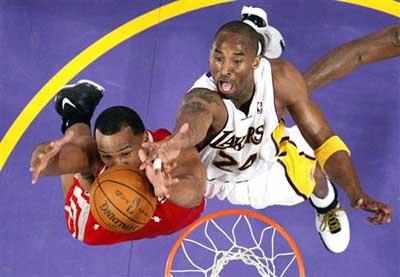 Houston Rockets forward Chuck Hayes (L) grabs a rebound from Los Angeles Lakers guard Kobe Bryant during the first half of Game 7 of an NBA Western conference playoff basketball series, on Sunday in Los Angeles. The Lakers see off the Rockets by crushing their opponents 89-70 to advance to the Western Conference finals. [Photo: sina.com.cn]