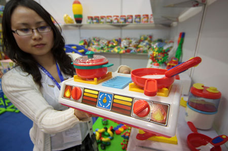 An exhibitor shows a toy kitchen in the three-day 11th Beijing International Toys and Preschool Tools Exhibition, opened in Beijing, capital of China, May 18, 2009. [Wu Changqing/Xinhua] 