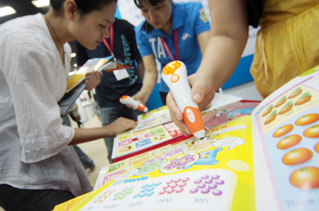  An exhibitor shows a pen-reader in the three-day 11th Beijing International Toys and Preschool Tools Exhibition, opened in Beijing, capital of China, May 18, 2009. [Wu Changqing/Xinhua]