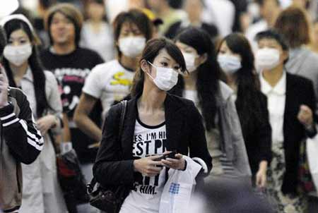 The total number of cases of A/H1N1 flu infections, both domestic and those contracted abroad, topped 130 in Japan Monday, according to Kyodo News calculations. People wear face masks at a shopping street in Kobe, western Japan, May 17, 2009. [Xinhua/Reuters]