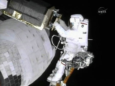 Astronaut John Grunsfeld, on Atlantis' robot arm, installs a thermal blanket cover on the exterior of of the Hubble Space Telescope in this image from NASA TV May 18, 2009. Grunsfeld and fellow spacewalker Andrew Feustel replaced a battery and remove and replaced one of three guidance sensors on the Hubble Space Telescope during their planned five hour 45 minute spacewalk. [Xinhua]