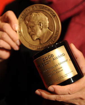 The Peabody award trophy honored to China's Sichuan Television is held by Professor Chan Yuen-ying, jury member of the Peabody Award board and general director of the Journalism and Media Studies Center of the University of Hong Kong after she receives the award on behalf of Sichuan Televsion, in New York, the U.S., May 18, 2009. [Xinhua]