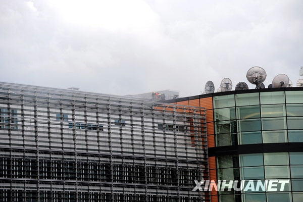 Firefighters try to put out a fire on the roof of the European Union headquarters in Brussels, capital of Belgium, on May 18, 2009. Fire broke out at the EU headquarters on Monday afternoon, forcing the evacuation of hundreds of workers and visitors. [Li Guotian/Xinhua]