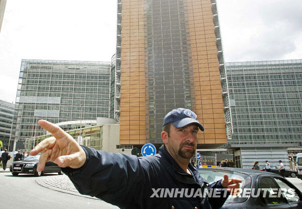 A Belgian police officer evacuates people from the European Commission headquarters in Brussels May 18, 2009. The headquarters of the EU's executive European Commission in Brussels was evacuated on Monday due to a fire, a Commission spokesman said. There were no reports of any injuries, a fire brigade official said, adding that the blaze appeared to have started in the basement of the building.[Xinhua/Reuters]