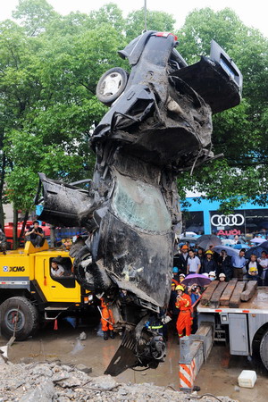 A severely deformed car is lifted at the site of a viaduct collapse accident that had killed 9 and injured 16 in downtown Zhuzhou, central China's Hunan province, Monday May 18, 2009. [Xinhua]