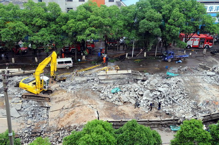 Rescuers examine the buried road at the site of a viaduct collapse accident that had killed 9 and injured 16 in downtown Zhuzhou, central China's Hunan province, Monday May 18, 2009. [Xinhua] 