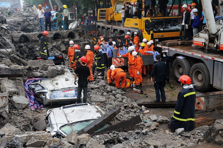 Rescuers examine the buried road at the site of a viaduct collapse accident that had killed 9 and injured 16 in downtown Zhuzhou, central China's Hunan province, Monday May 18, 2009. [Xinhua]