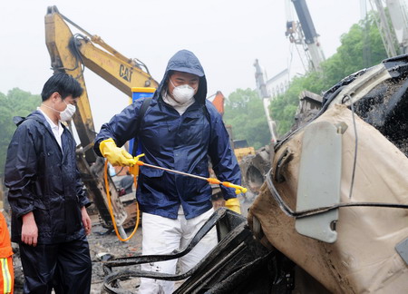 Health worker sanitizes at the site of a viaduct collapse accident that had killed 9 and injured 16 in downtown Zhuzhou, central China's Hunan province, Monday May 18, 2009. [Xinhua]