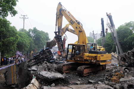 Rescuers examine the buried road at the site of a viaduct collapse accident that had killed 9 and injured 16 in downtown Zhuzhou, central China's Hunan province, Monday May 18, 2009. [Xinhua]