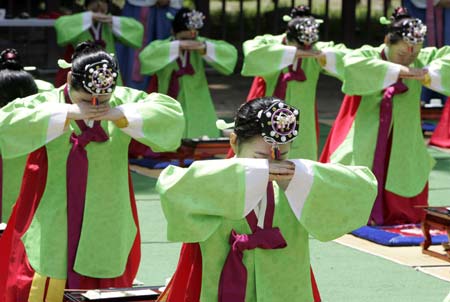  Women in traditional Korean costume bow down to their elders during a ceremony celebrating the Coming-Of-Age Day at a university in Seoul May 18, 2009. The traditional Coming-Of-Age ceremony is a ceremony that endows young boys and girls at the age of 20, who have lived under the protection of families, with individual authorities.[Xinhua/Reuters]