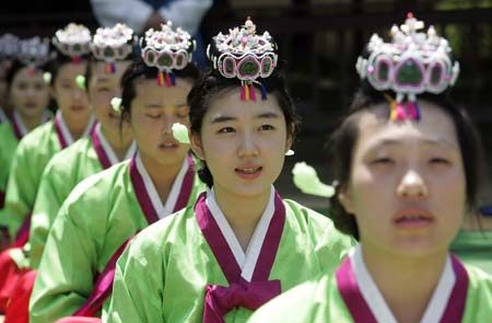  Women in traditional Korean costume bow down to elders during a ceremony celebrating the Coming-Of-Age Day at a university in Seoul May 18, 2009. The traditional Coming-Of-Age ceremony is a ceremony that endows young boys and girls at the age of 20, who have lived under the protection of families, with individual authorities. [Xinhua/Reuters]