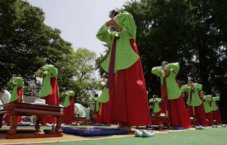  Women in traditional Korean costume bow down to elders during a ceremony celebrating the Coming-Of-Age Day at a university in Seoul May 18, 2009. The traditional Coming-Of-Age ceremony is a ceremony that endows young boys and girls at the age of 20, who have lived under the protection of families, with individual authorities. [Xinhua/Reuters]