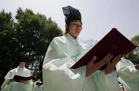 Men in traditional Korean costume read documents declaring their being adults during a ceremony celebrating the Coming-Of-Age Day at a university in Seoul May 18, 2009. The traditional Coming-Of-Age ceremony is a ceremony that endows young boys and girls at the age of 20, who have lived under the protection of families, with individual authorities. [Xinhua/Reuters]