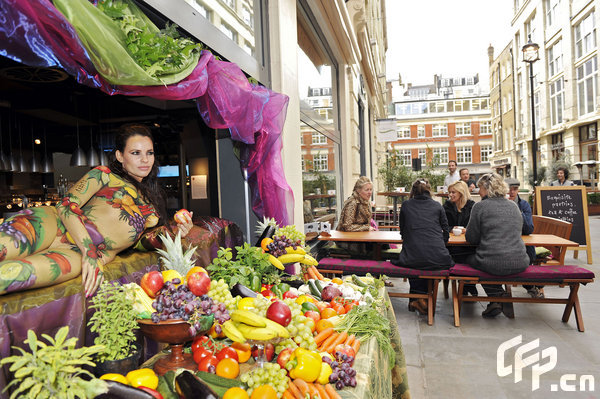 Body-painted model Juliet Johns poses in the window of tibits vegetarian restaurant on Heddon Street in London to celebrate National Vegetarian Week, which runs from 18th until 24th May. [CFP]