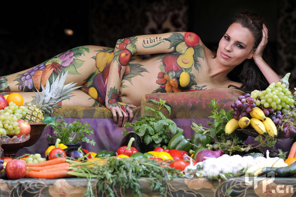 Body-painted model Juliet Johns poses in the window of tibits vegetarian restaurant on Heddon Street in London to celebrate National Vegetarian Week, which runs from 18th until 24th May. [CFP]