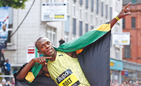 Jamaican athlete Usain Bolt poses for pictures after winning a 150m street race in central Manchester with a world record time of 14.35 seconds, in Manchester, England, on Sunday. 