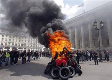 Employees from Continental tire company of Clairoix, northern France, demonstrate around burning tires, in front of former Paris Stock Exchange building, in Paris, Monday May 18, 2009.[Christophe Ena/CCTV/AP Photo] 