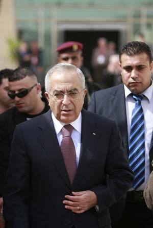 Palestinian Prime Minister Salam Fayyad (front) is escorted by a bodyguard after attending a local conference in the West Bank city of Ramallah March 8, 2009.