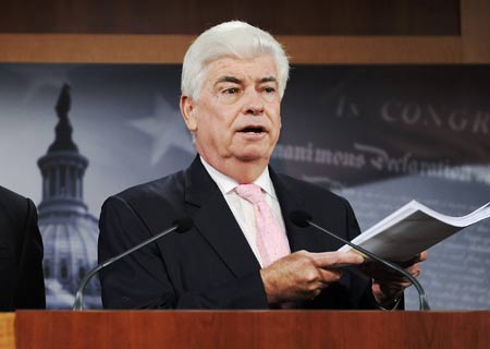 U.S. Senator Christopher Dodd (D-CT) holds up a copy of a stalled plan for dealing with the current financial crisis as he hold a news conference at the U.S. Capitol in Washington, Sept. 26, 2008.[Xinhua]