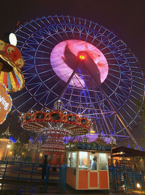 Photo taken on May 20, 2009 shows the super ferries wheel in nocturnal neon lightening inside the Amusement Park of Ferries Wheel by the side of the Golden Rooster Lake, upon its opening to public entertaining, in Suzhou, east China's Jiangsu Province. The Amusement Park of Ferries Wheel covers an area of some 40,000 square meters and comprises corsair, water roller coasters, and other fun facilities galore. The symbolic ferries wheel stands at 120 meter high, consists of 60 cabins capable of accommodating up to 360 visitors a time.(Xinhua/Yang Haishi)