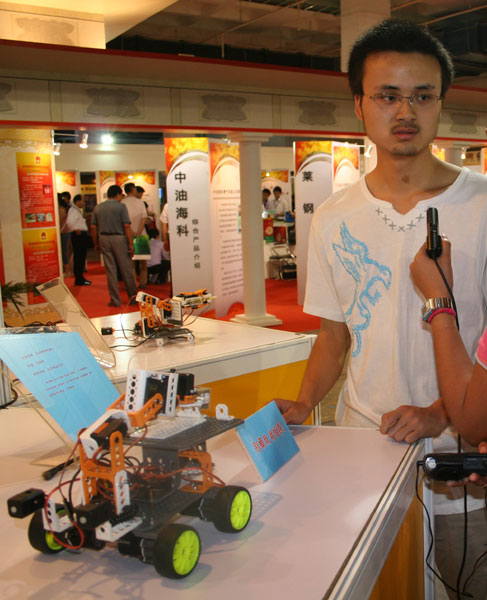 Ma Zhenguan (L), a sophomore from Beijing Forestry University, introduces the auto jointing robot he made at the 12th China Beijing International High-tech Expo in China International Exhibition Center in Beijing on Wednesday, May 20, 2009. [Photo: CRIENGLISH.com]