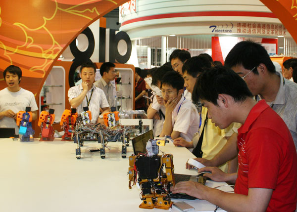 Visitors experience the robots made by Beijing Hangood Science and Technology Company at the 12th China Beijing International High-tech Expo in China International Exhibition Center in Beijing on Wednesday, May 20, 2009. [Photo: CRIENGLISH.com] 