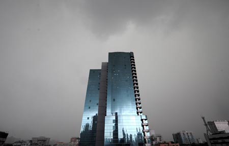 Buildings are shrouded by dark clouds before the rain in Guangzhou, capital of south China's Guangdong Province, May 20, 2009. A rainstorm hit Guangzhou Wednesday and affected drainage system and traffic. [Chen Yehua/Xinhua]