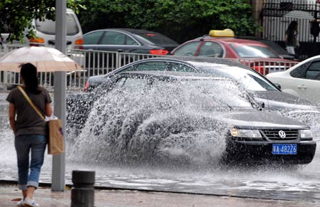 Cars run in the rain in Guangzhou, capital of south China's Guangdong Province, May 20, 2009. A rainstorm hit Guangzhou Wednesday and affected drainage system and traffic. [Chen Yehua/Xinhua]